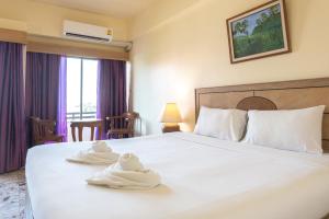 Postel nebo postele na pokoji v ubytování Nonthaburi Palace Hotel