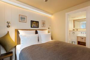 a bedroom with a large bed with white pillows at LOEV - VELA Hotels in Binz