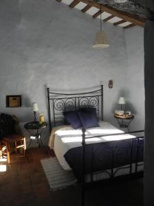 a bedroom with a black bed with blue pillows at BAIX EMPORDÀ. Increíble casa en pueblo medieval in Cruïlles