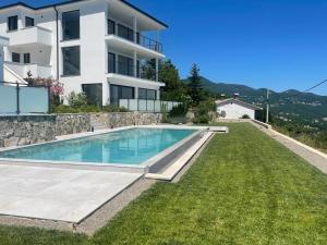 a villa with a swimming pool and a house at Kvarner Luxury Loft in Lovran