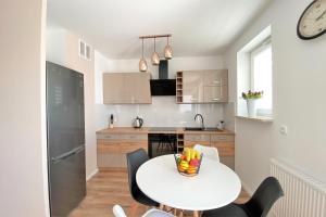 a small kitchen with a white table and chairs at Apartament Solaris in Mielec