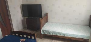 a bedroom with a bed and a flat screen tv at GEO Vake Guest House in Tbilisi City