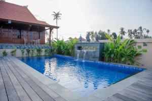 a swimming pool in front of a house at Victory Munggu in Canggu