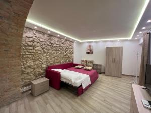 1 dormitorio con cama y pared de piedra en Al Vicolo Casa Vacanze - Casa ''XX Settembre'' en Roccadaspide
