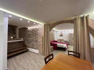 Sala de estar con cama roja y mesa en Al Vicolo Casa Vacanze - Casa ''XX Settembre'' en Roccadaspide
