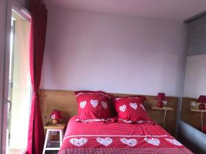 um quarto com uma cama vermelha com almofadas vermelhas em Charmant appartement em Saint-Gervais-les-Bains