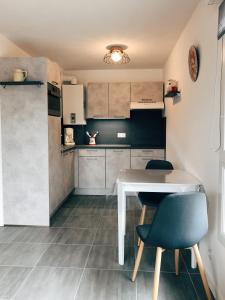 uma pequena cozinha com uma mesa branca e duas cadeiras em Charmant appartement em Saint-Gervais-les-Bains