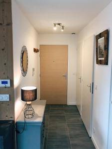 a hallway with a door and a table with a lamp at Charmant appartement in Saint-Gervais-les-Bains