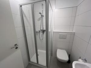 a bathroom with a shower and a toilet and a sink at Appartementhaus Nige Ooge Ferienwohnung Nr. 1 in Cuxhaven +3 photos