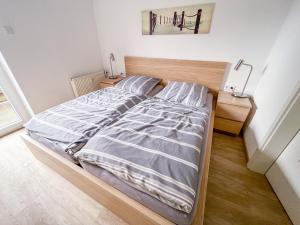 ein Schlafzimmer mit einem Bett mit einem Kopfteil aus Holz in der Unterkunft Appartementhaus Nige Ooge Ferienwohnung Nr. 1 in Cuxhaven