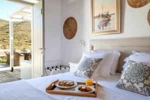 a bedroom with a tray of food on a bed at Ursa Major Suites in Tinos Town