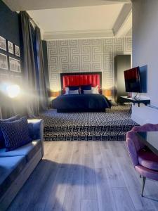 a bedroom with a bed and a couch and a television at 62 Castle Street Hotel in Liverpool