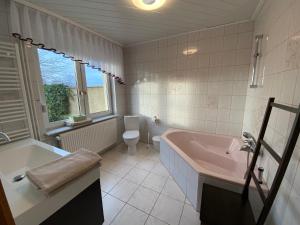 a bathroom with a tub and a toilet and a sink at Ferienhaus Spreewald in Luckau +16 photos