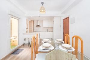 una cucina e una sala da pranzo con tavolo e sedie di BHost - Soho a Málaga
