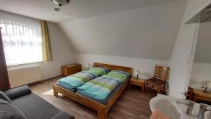 ein Schlafzimmer mit einem Bett, einer Couch und einem Waschbecken in der Unterkunft Seevilla Wietjes Whg 5 in Baltrum