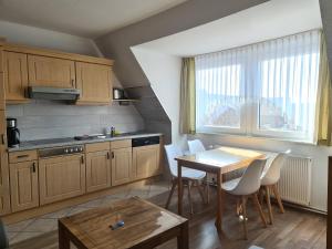 eine Küche mit Tisch und Stühlen und ein Esszimmer in der Unterkunft Seevilla Wietjes Whg 5 in Baltrum
