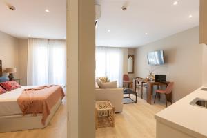 ein Schlafzimmer und ein Wohnzimmer mit einem Bett und einem Sofa in der Unterkunft Apartamentos Martalia Arenal in Ronda