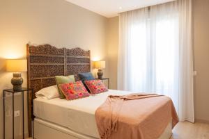 1 dormitorio con cama con almohadas y ventana en Apartamentos Martalia Arenal en Ronda