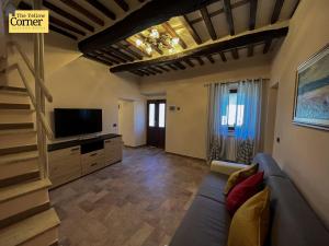 sala de estar con sofá y TV en Yellow Corner, en Bagni di Lucca