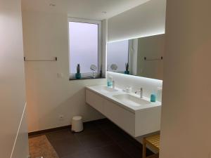 a white bathroom with a sink and a mirror at Q Studio in Herzele +7 photos