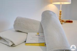 a pile of towels and a book on a table at Ocean Cottage 3 étoiles - 50 m2 - Etang Salé Les Bains in Étang-Salé les Bains