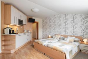 a bedroom with a bed and a kitchen at Hotel Osvit in Mladá Boleslav