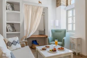 uma sala de estar com uma mesa com comida em Ursa Major Suites em Tinos Town