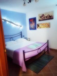 - une chambre dotée d'un lit avec un cadre violet dans l'établissement casa vacanze verdeblu, à SantʼEusanio del Sangro