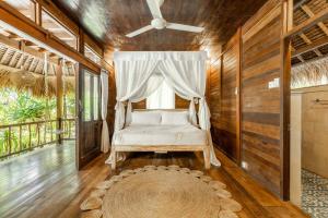 Schlafzimmer mit einem Bett, einem Fenster und einem Teppich in der Unterkunft Tigerlillys Boutique Hotel in Nusa Lembongan