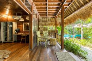an open porch with a table and chairs at Tigerlillys Boutique Hotel in Nusa Lembongan
