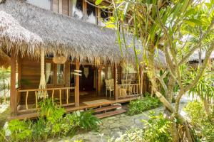 une maison en bois avec un toit de chaume dans l'établissement Tigerlillys Boutique Hotel, à Nusa Lembongan
