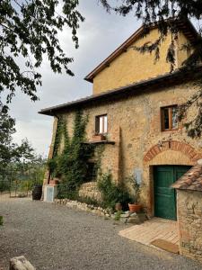 a large brick building with a green garage at Campora House in Tavarnelle in Val di Pesa