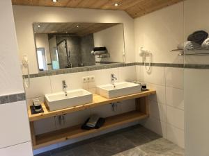 a bathroom with two sinks and a mirror at Haus Landschisott in Tschagguns +36 photos