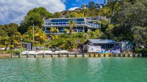 a building on the shore of a body of water at Kawau Lodge Boutique Resort in Kawau Island