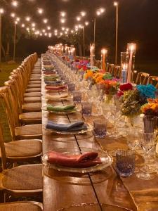 a long table with chairs and a long line of glasses at Agrisalotto in Cortona