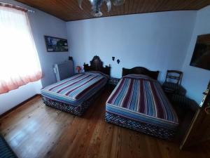 Habitación con suelo de madera y 2 camas. en Alla Curva di Elia Manzoni, en Malè