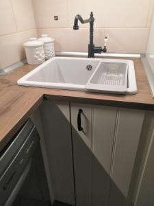 a white sink with a faucet on a kitchen counter at OlivApartment in Budapest