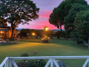 a sunset over a yard with a white fence at Agrisalotto in Cortona