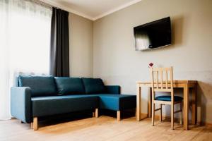 ザトルにあるRóża Roomsの青いソファとテーブルのあるリビングルーム