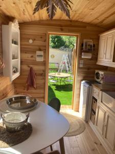 a kitchen with a table in a tiny house at Roulottes & SPA du pont des charrettes in Uzès