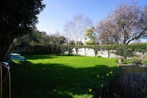 a green yard with a picnic table and a lake at Seashells - Bembridge in Bembridge