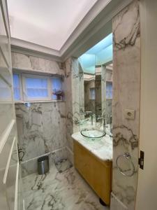 een badkamer met een wastafel en een glazen douche bij OHH -Oporto Center- Luxury Apartment in Porto