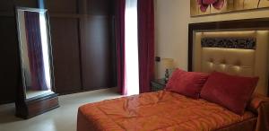 ein Schlafzimmer mit einem Bett mit roten Kissen darauf in der Unterkunft APARTAMENTO REFORMADO Y LUMINOSO EN AGUILAR DE LA FRONTERA in Aguilar de la Frontera