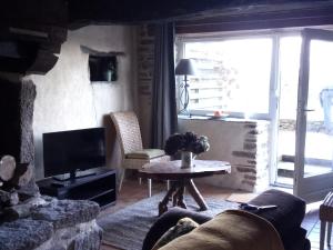 CommanaにあるPetite maison dans les Monts d'Arrée TY COZのリビングルーム(ソファ、テーブル、テレビ付)
