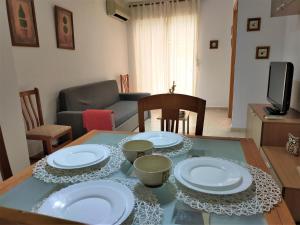 einen Tisch mit Tellern und Schüsseln im Wohnzimmer in der Unterkunft ACV - Isla Park-1ª Linea Planta 1 Sur in Oropesa del Mar