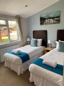 a bedroom with two beds and a window at Crystal Lodge with Hot Tub in Malton
