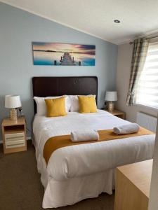 a bedroom with a large bed with yellow pillows at Crystal Lodge with Hot Tub in Malton