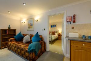 a living room with a couch with blue pillows at Beachcombers Apartments in Newquay