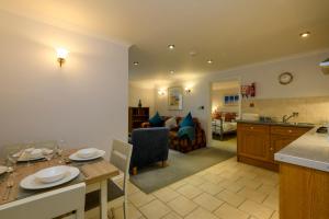a kitchen and living room with a table and a dining room at Beachcombers Apartments in Newquay