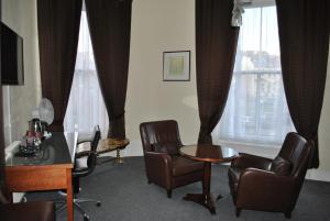 a waiting room with chairs and a table and window at Town House Rooms in Hastings